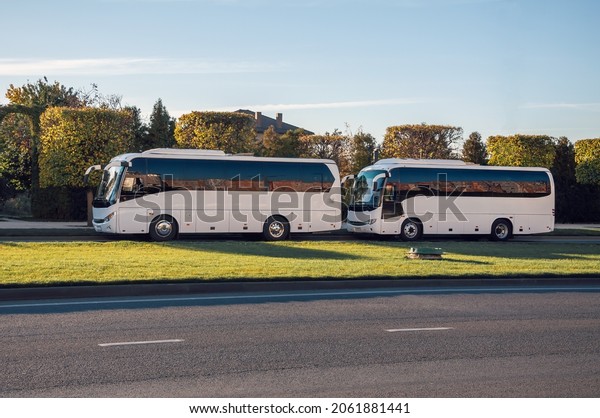 Krasnodar, Russia -\
October 21 2012: Street photography. Urban minimalism. Reflection\
in the windows of two buses. Two white passenger buses standing\
along the road\
parked.