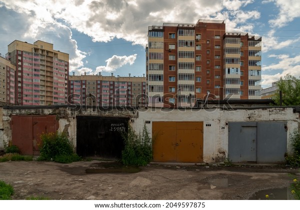 Krasnoyarsk, Krasnoyarsk Region, RF -\
July 1, 2021: Garages are in a row in a residential area on a\
summer day, one of them has an inscription in Russian -\
sell.