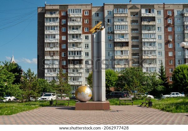 Krasnoyarsk, Krasnoyarsk Region, RF - July 16,\
2021: Stela-monument to the polar pilot Major General Vasily\
Molokov with a model of the R-5 airplane against the background of\
a residential\
building.