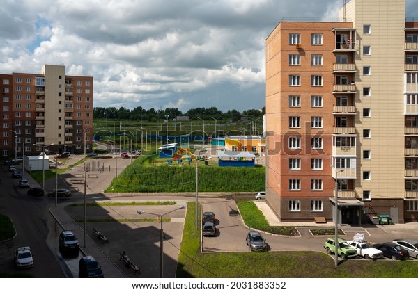 Krasnoyarsk, Krasnoyarsk Region, RF -\
July 20, 2021: Top view of a common courtyard of apartment\
buildings with cars parked on the sidewalk on a summer\
day.