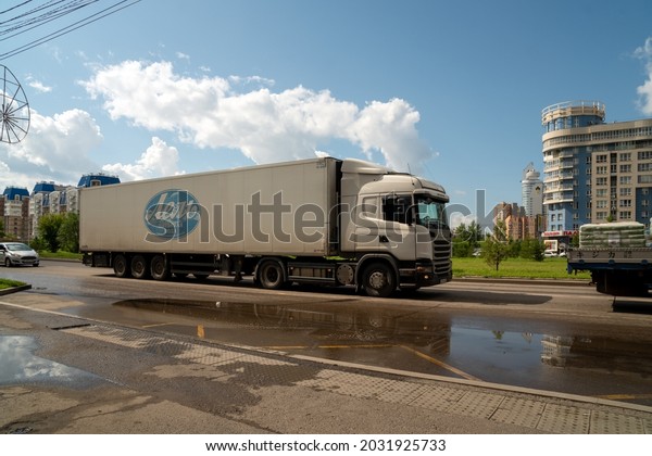 Krasnoyarsk,\
Krasnoyarsk Region, RF - July 20, 2021: A large lorry, with an\
inscription in Russian - Drinking water Lel, is driving along a\
city street after a rain in\
summer.