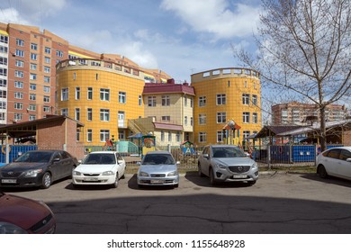 KRASNOYARSK, RF- May 7, 2018: The Building Of The Kindergarten In A Residential Neighborhood Of The Krasnoyarsk City With Parked Cars In Front Of It, Against A Background Of A Residential Houses.