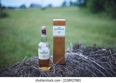 Krasnoyarsk, Russia -08.02.2018 A bottle of Glenlivet single malt Scotch whiskey with a box sits on a haystack.