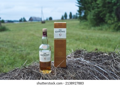 Krasnoyarsk, Russia -08.02.2018 A bottle of Glenlivet single malt Scotch whiskey with a box sits on a haystack.