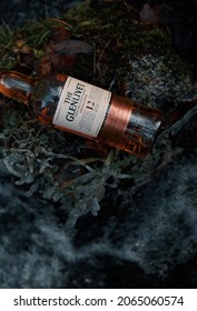 Krasnoyarsk, Russia - 10.24.2017
A bottle of Glenlivet single malt Scotch whiskey lies by a stream with icy grass.