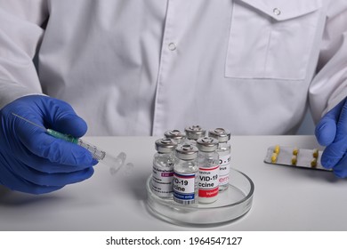 Krasnoyarsk, Russia. April 27, 2021. Popular Covid-19 Vaccine Phials In A Glass Petri Dish. Doctor Explores Different Covid Vaccines On A Lab Desk. How To Choose Valid Coronavirus Treatment Drugs.