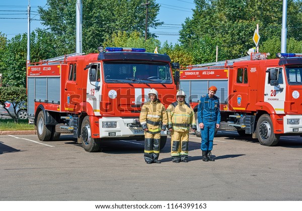 Krasnoyarsk, Russia - August 25,\
2018: The solemn delivery of new fire trucks to crews of MES dated\
for a celebrating the birthday of the city. Crew in front of the\
car.