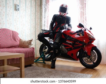 KRASNOYARSK, RUSSIA - December 21, 2018: Beautiful Motorcyclist In Full Gear And Helmet On A Red And Black Honda 2005 CBR 600 RR (PC37) In House.