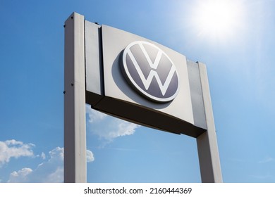 Krasnoyarsk, Russia - May 19, 2022: Close-up Volkswagen brand logo on against blue sky background. Dealership centre of car shop.The company is owned by Volkswagen AG.