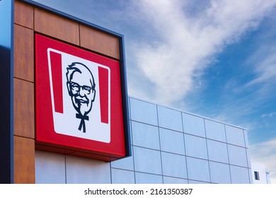 Krasnoyarsk, Russia - May 19, 2022: KFC restaurant logo on glass facade building. Portrait of Colonel Sanders - the symbol of the KFC. KFC is a fast food restaurant chain specializes in fried chicken