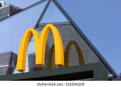Krasnoyarsk, Russia - May 24, 2022: Close-up of McDonalds logo on glass facade of the building. Symbolic yellow iconic M. McDonald's sells business and leaves Russia