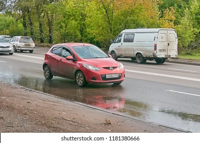 Krasnoyarsk, Russia - September 16, 2018: Mazda Demio Car With The Trailer Moves On The Country Road.