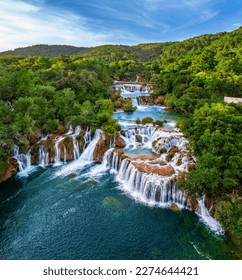 Krka, Croatia - Aerial view of the beautiful Krka Waterfalls in Krka National Park on a bright summer morning with green foliage, turquoise water and blue sky - Shutterstock ID 2274644421