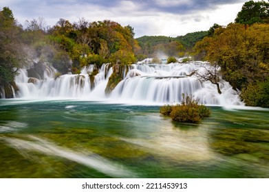 Krka National Park During Colorful Autumn Travel Destination In Dalmatia, Croatia, Europe. Fall Colors Leafs On Trees. Krka Waterfalls And Water In Sunny Morning Light With Fog. Landscape Photography.