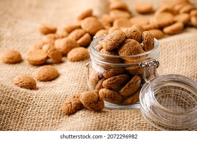 Kruidnoten cookies in glass jar on sackcloth. Pepernoten, traditional sweets, strooigoed. Dutch holiday Sinterklaas greetings card concept of Saint Nicholas day with copy space.
