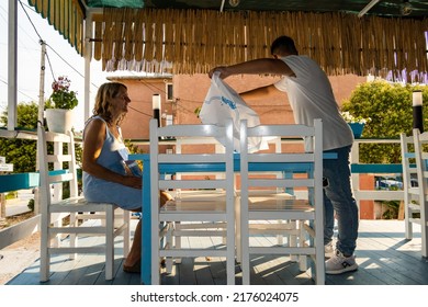 Ksamil, Albania  July 4, 2022 A Woman Sits Down At An Outdoor Local Restaurant.