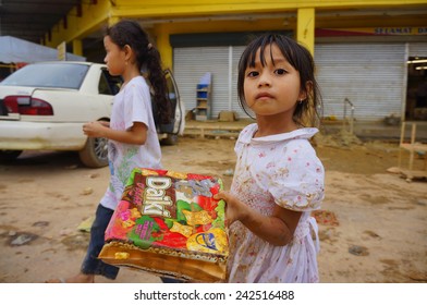 KUALA KRAI, KELANTAN - JANUARY 2: Little girl collecting food discarded by the owner of flooded supermarket in Kuala Krai, aftermath the worst flood that ever hit Kelantan, Malaysia on January 2, 2015