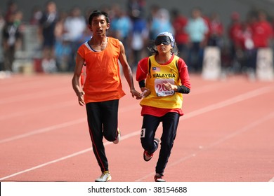 KUALA LUMPUR - AUGUST 15: Malaysia's Visually Impaired Athlete Siti Najihah Running With A Guide At The Track And Field Event Of The Fifth ASEAN Para Games On August 15, 2009 In Kuala Lumpur, Malaysia.