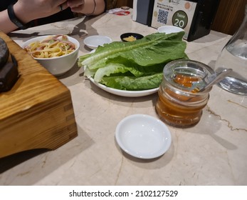 Kuala Lumpur, Malaysia 1 Dec. 2021: Vegetables On Plate Ready For Steamboat And Chili Sauce On Table. Selective Focus.