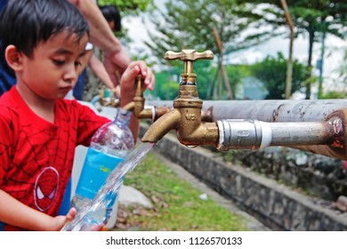 KUALA LUMPUR MALAYSIA -14 APRIL 2018: Selective Focus Of Child Getting Water From Water Pipe At Ampang, Kuala Lumpur Due To Water Disruption.