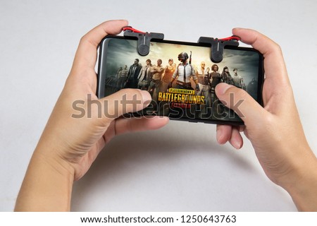 Kuala Lumpur, Malaysia - 2 December 2018: Hand holding a smartphone with Player's Unknown Battleground also known as PUBG online shooting gaming