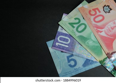 Kuala Lumpur, Malaysia; 24 December 2020. Canadian Dollar (CAD) on black background and new year 2021. Concept for business, finance, economy, investment and trade. 