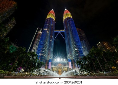 Kuala Lumpur, MALAYSIA - 31 August 2021: Petronas Twin Towers (known as KLCC) displaying the colors of the Malaysian flag, which are red, yellow and blue during the 64th National Day celebration.