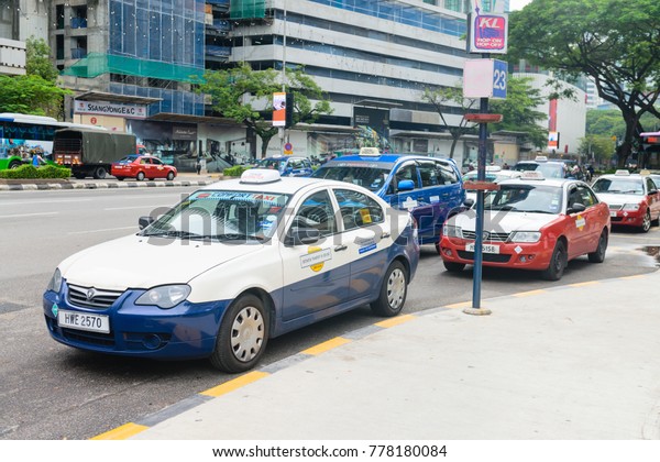 KUALA LUMPUR, MALAYSIA - 31 OCT 2014: Blue comfort\
and red econom KL taxi cars are waiting for clients in the city\
center KLCC