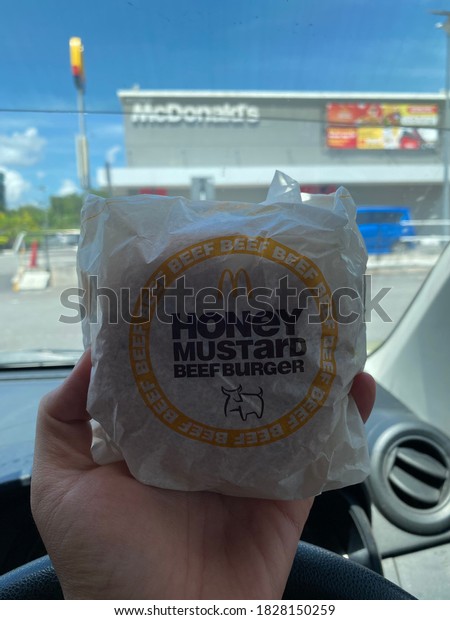 Kuala Lumpur, Malaysia - 5 October,2020:\
McDonald\'s Honey Mustard Beef Burger in car on blurry McDonald\'s\
restaurant background, noise and grain\
effects.