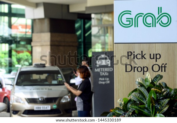 Kuala Lumpur, Malaysia - 6 June2019 :\
\
Passenger taking a grab car service at grab car pick-up and\
drop-off point at a shopping mall in Kuala\
Lumpur.