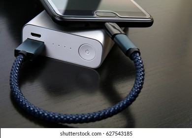 KUALA LUMPUR, MALAYSIA - APRIL 10, 2017: A mobile phone connected to a power bank for travelling purposes.
