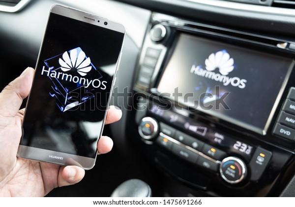 KUALA\
LUMPUR, MALAYSIA, August, 11, 2019: Huawei officially announced its\
new operating system, HarmonyOS. Illustrative visual of HarmonyOS\
on smat phone and vehicle car honor smart\
screen