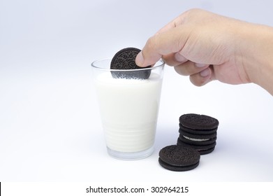 KUALA LUMPUR, MALAYSIA - AUGUST 3rd 2015. Hand Holding Oreo Cookies Dunk To Glass Of Milk. Oreo Is A Sandwich Cookie With A Sweet Cream Is The Best Selling Cookie In The US.