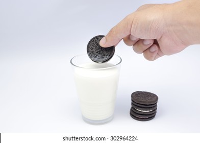 KUALA LUMPUR, MALAYSIA - AUGUST 3rd 2015. Hand Holding Oreo Cookies Dunk To Glass Of Milk. Oreo Is A Sandwich Cookie With A Sweet Cream Is The Best Selling Cookie In The US.