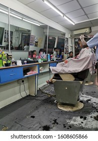 Kuala Lumpur, Malaysia – January, 2020: Young Boy Having His Hair Cut At A Mamak Barbershop. Mamak Barbershop Is Among Favourite Shop For Its Cheap And Professional Services.