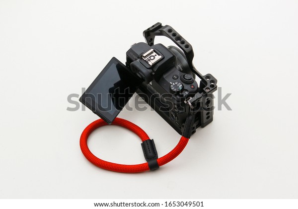 kuala lumpur,\
malaysia - january 2020: camera with grip and hand wrist strap.\
isolated picture. micro\
lens.