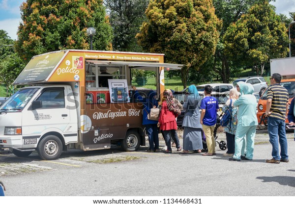 KUALA LUMPUR, MALAYSIA - JULY 12, 2018:\
Customers order meals from a popular food truck during their lunch\
hour at Kuala Lumpur Food Truck\
Festivals.