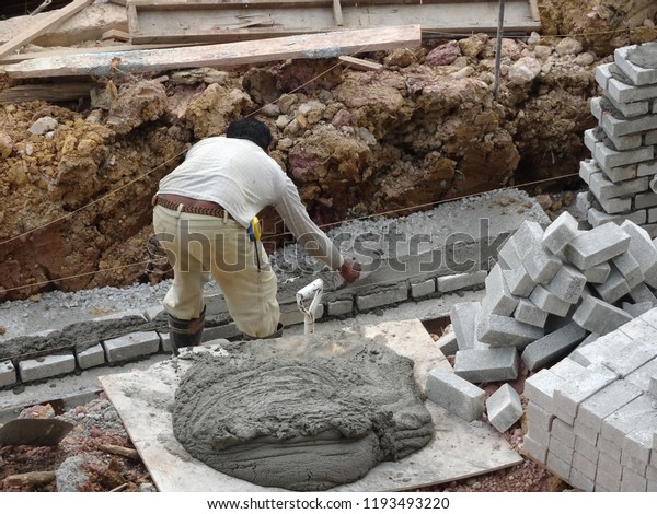 KUALA LUMPUR, MALAYSIA -JUNE 1, 2018: Bricklayer lay\
sand brick and stacked it together using cement mortar to form\
monsoon drain wall at the construction site. Necessary tools\
required for this job. 