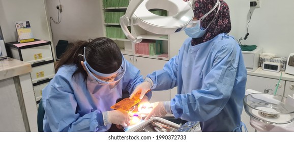 KUALA LUMPUR, MALAYSIA - JUNE 12, 2021 : Dentist Fillings Treatment Process For 9 Years Old Kids During Covid 19 Pandemic With All Staff And Doctor Wear Mask And Face Sheild