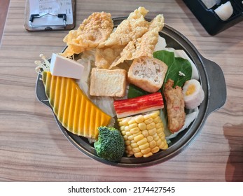 Kuala Lumpur, Malaysia- June 19, 2022 : Variety Of Assorted Steamboat Ingredient Fish Ball, Noodles, Pumpkin, Corn, Bean Curd And Many More At Restaurant Table. Selective Focus.