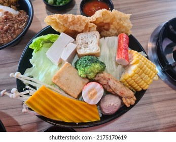 Kuala Lumpur, Malaysia- June 19, 2022 : Variety Of Assorted Steamboat Ingredient Fish Ball, Noodles, Pumpkin, Corn, Bean Curd And Many More At Restaurant Table. Selective Focus.