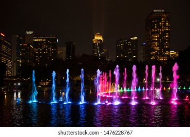 Kuala Lumpur, Malaysia - June 2018: Beautiful colorful musical fountain at night with background of Petronas Twin Towers and Suria KLCC. Petronas Twin Tower from KLCC Park with rainbow fountains