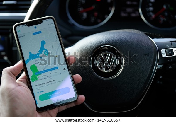 KUALA LUMPUR, MALAYSIA - JUNE 6TH, 2019:\
modern lifestyle with smartphone to stay connected and browsing\
favourite Apps. Find Gas/Petrol Station and makes online payment\
via SETEL apps on\
Smartphone
