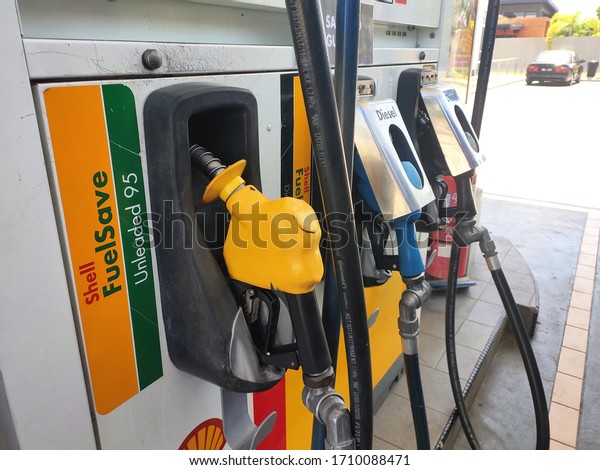 KUALA LUMPUR, MALAYSIA -MARCH 26,\
2020: Fuel nozzle used to pumping petrol into vehicle at the petrol\
station. Nozzles should be put in place when not in\
use.