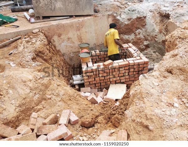 KUALA LUMPUR, MALAYSIA -MARCH 29, 2017: Bricklayer lay\
clay brick and stacked it together using cement mortar to form\
walls at the construction site. Necessary tools required for this\
job. 