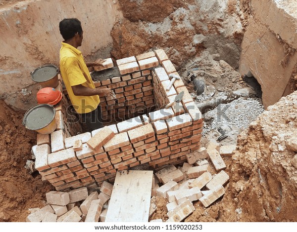 KUALA LUMPUR, MALAYSIA -MARCH 29, 2017: Bricklayer lay\
clay brick and stacked it together using cement mortar to form\
walls at the construction site. Necessary tools required for this\
job. 
