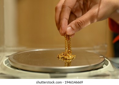 Kuala Lumpur, Malaysia : March 30, 2021 - Islamic Pawnbrokers consultant, weigh jewelry for used gold sale and purchase transactions in sharia law.