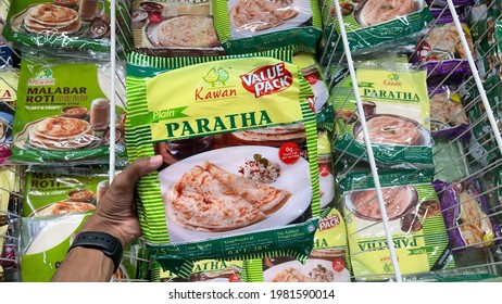 Kuala Lumpur, Malaysia, MAY 25th 2021: Hand Hold Ready Made Frozen Roti Paratha (Indian Bread) In Super Market Fridge.