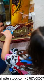 Kuala Lumpur, Malaysia - May 3, 2021: Family Opening Aidilfitri Big Decorated Hampers Gift Of Assorted Malaysia Foods Together At Home.