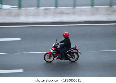 Kuala Lumpur, Malaysia Nov 2020: Panning shot of a man ride on Honda 125 RS motorcycle in motion blur on the road. - Shutterstock ID 1926855311